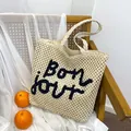 Hohl gewebte Strohtasche mit Bon jour Stickerei und hellkhakifarbenem Design - Weiß & Schwarz