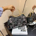 Elegant black satin handbag with floral embroidery and rhinestone handle in golden finish - Black