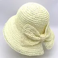 Détail d'un chapeau de paille à large bord avec un grand nœud décoratif élégant crème - M (56-58cm) / Crème