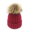 Dettaglio del berretto in maglia bordeaux con un grande pompon di pelliccia naturale - Adulto / Rosso