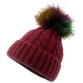 Close-up of wine red chunky cable knit beanie with vibrant multicolored faux fur pom-pom - Burgundy