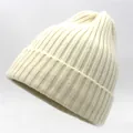 Detail of cream rib-knit wool beanie showing thick vertical stripe texture and cuffed brim - Off White