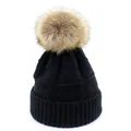 Detail of black knit beanie featuring a large fluffy faux fur pom-pom and ribbed edge - M / Black