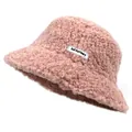 Detail of pink teddy fleece bucket hat with a white rectangular letter logo label - Pink