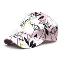 Detail view of pink satin baseball cap with colorful floral prints and curved brim - M / Pink