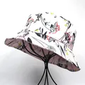 Close-up of pink silk-like bucket hat with floral print on black metal display stand - M (56-58cm) / Pale Pink Line Plant Style / Pink