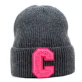 Detail of grey knitted beanie with a large pink letter C embroidery patch on the front cuff - Gray