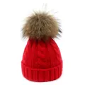 Detalle de un gorro de invierno rojo de punto de ochos con un pompón de pelo suave - Niños / Rojo