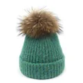 Dettaglio del berretto in maglia a trecce verde smeraldo con pompon in pelliccia marrone - M(56-58cm) / Verde