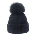 Gedetailleerde close-up van een zwarte gebreide muts met een pluizige echte vossenbont pompon - M (56-58cm) / Zwart