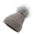 Close-up of mixed purple knit texture and fluffy grey pom-pom on top of a winter beanie - One Size / Khaki