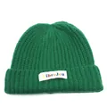 Dettaglio del berretto in maglia verde scuro con etichetta tessuta colorata LibreJeu - Verde