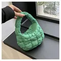 Detail of bright green quilted puffer handbag featuring a zipper and padded texture - Light Green