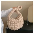 Detail of beige quilted shoulder bag featuring soft textured fabric and zipper closure - Khaki