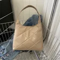 Gewatteerde beige hobo tas in metalen mandje met een blauwe spijkerjas - Khaki