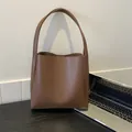 Grande borsa tote vintage in pelle marrone scuro con logo inciso su una scrivania - Marrone