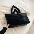 Grande borsa tote imbottita nera trapuntata con etichetta fashion e spalline larghe - Nero