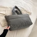 Borsa tote grigia trapuntata effetto piumino con targhetta su sfondo bianco soffice - Grigio