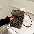 Close-up of leopard print canvas mini crossbody bag with leather trim and horn buckle - Leopard Print