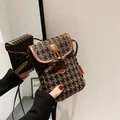 Detail of vintage houndstooth crossbody phone bag with brown leather trim and toggle closure - Houndstooth