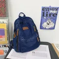 Deep blue denim backpack with brown leather patches and multiple utility pockets - Dark Blue