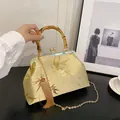 Golden silk brocade handbag with bamboo handle and elegant leaf embroidery - Gold