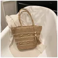 Close-up of woven straw tote bag featuring decorative wooden beads and long tassels - Beige