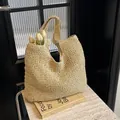 Beigefarbene handgewebte Strandtasche aus Stroh mit breitem Schultergurt für den Urlaub - Gebrochenes Weiß