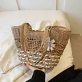 Handwoven straw tote bag in natural and cream contrast with a purple floral charm - Khaki