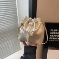 Bolso saco beige con bordados florales, asa de perlas y cadena metálica dorada - Blanco