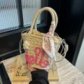 Off-white straw handbag with pink 'hello' script and silk scarf on marble background - Rose Pink