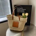 Beige geflochtene Strohtasche mit braunen Ledergriffen und geräumigem Sommerdesign - Gebrochenes Weiß