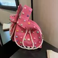 Pink knitted handbag with colorful pearl accents and large white pearl strap detail - Pink