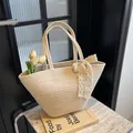 Französische geflochtene Tragetasche in Creme mit eleganter Spitzenschleife für den Sommer - Gebrochenes Weiß