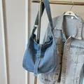 Light blue denim crossbody tote bag with adjustable strap and front pocket detail - Light Blue