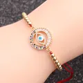 Verstellbares rotes Seilarmband mit goldenen Perlen und buntem Evil Eye Anhänger am Handmodell - Rote Schnur Perlen Böser Blick Stil 6