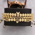 Dreiteiliges goldenes Herren-Perlenarmband-Set mit Kronen- und Totenkopf-Anhängern auf Kissen - Goldener Geisterkopf