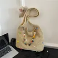 Beige straw woven shoulder bag featuring colorful pom-poms and beaded charm strap - Off White