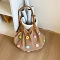 Close-up of handmade crochet tote bag featuring multi-color floral 3D embroidery detail - Brown