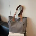 Bolso tote minimalista de lona color topo con asas marrones y bolsillo frontal de botón - Gris