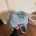 Sac bandoulière en jean bleu clair avec écusson en cuir brun et sangle réglable au ton doux - Bleu clair