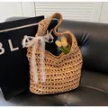 Détail du sac en paille tressée avec un nœud en dentelle blanche et texture naturelle - Kaki