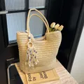 Beigefarbene gewebte Stroh-Tote-Bag mit Quastendetail und Evil-Eye-Perlen-Anhänger - Beige