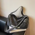 Zwarte gewassen denim crossbodytas met REPLACED-tekst en een brede zachte schouderband - Zwart