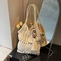 Bohemian off-white crochet tote bag with fringe detail and wooden beads on a book - Beige