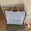 Light blue floral waterproof tote bag with printed letters and spacious trapezoid design - Blue