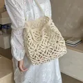 Cremeweiße Häkeltasche mit hohlem Blumenmuster in einem Lifestyle-Szenario gezeigt - Beige