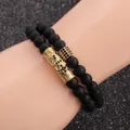 Detail of matte black beaded bracelets with gold hollow metal charms on hand model - Tube and Cube Style / Gold