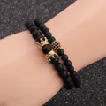 Detail of matte black beads bracelet set featuring golden crown and micro-pave charms - Double Crown and Full Drill Ball Style / Gold