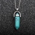 Conical turquoise stone pendant necklace with silver chain on sparkling black background - Turquoise